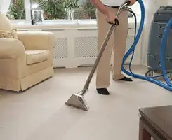 Carpet cleaning professional removing dirt and stains with a hot-water extraction tool in a home, Cambridge, MA.